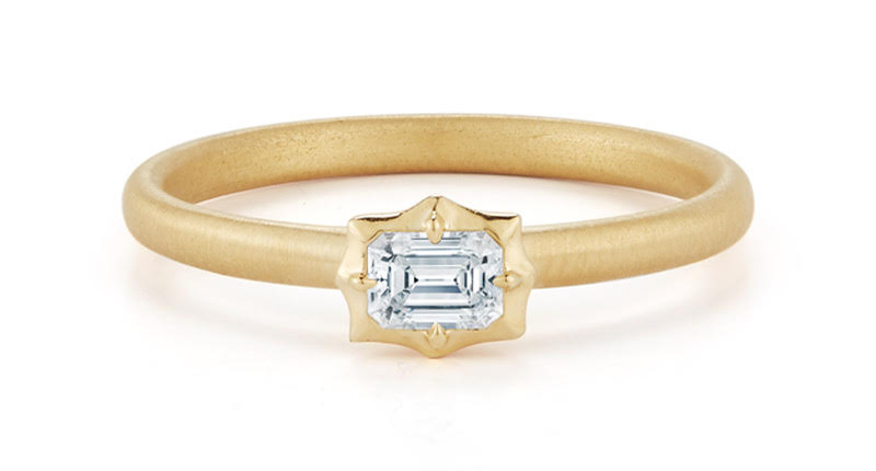 A simple stacking ring, featuring an emerald-cut diamond, representing “The Vanguard.” 