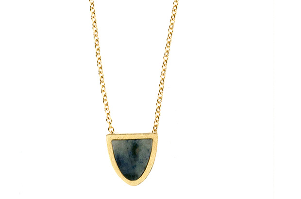This pendant is set with a half oval-shaped ethically sourced sapphire slice and hangs on an 18-inch chain, available in sterling silver ($350) or 14-karat yellow gold ($596).