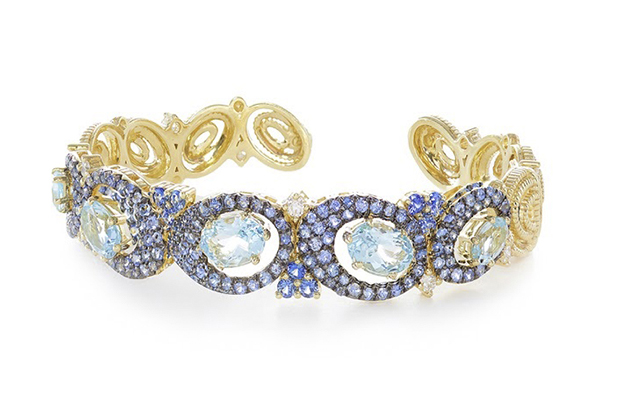 The “Caserta” cuff by Judith Ripka features blue sapphires, blue topaz and diamonds set in 18-karat yellow gold, with the brand’s signature hinge ($18,000). 