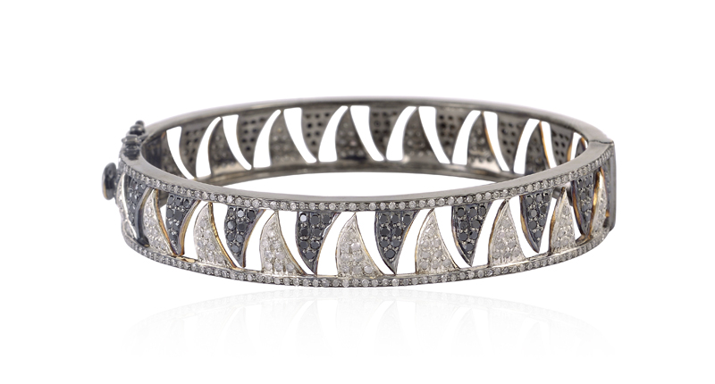 This 18-karat gold and sterling silver bracelet from Meghna Jewels’ Claw collection features white and black diamonds ($4,400).
