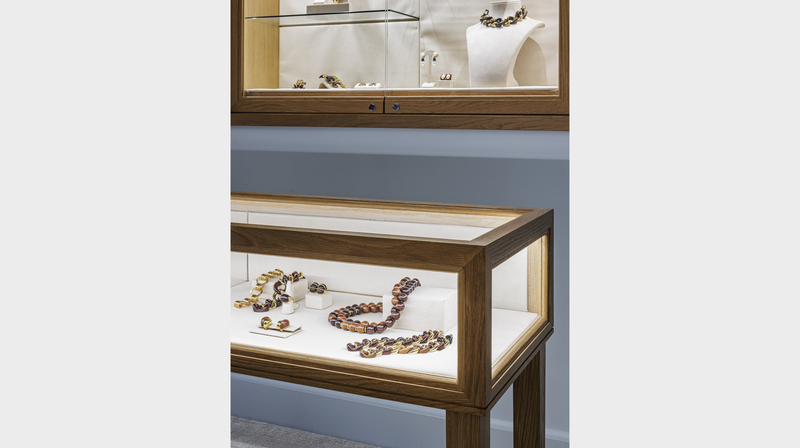 Jewels on display in walnut vitrines