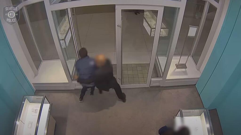 Surveillance footage shows the security guard attempting to stop the suspect. (Image courtesy of the Seattle Police Department) Surveillance footage Tiffany & Co. Seattle robbery
