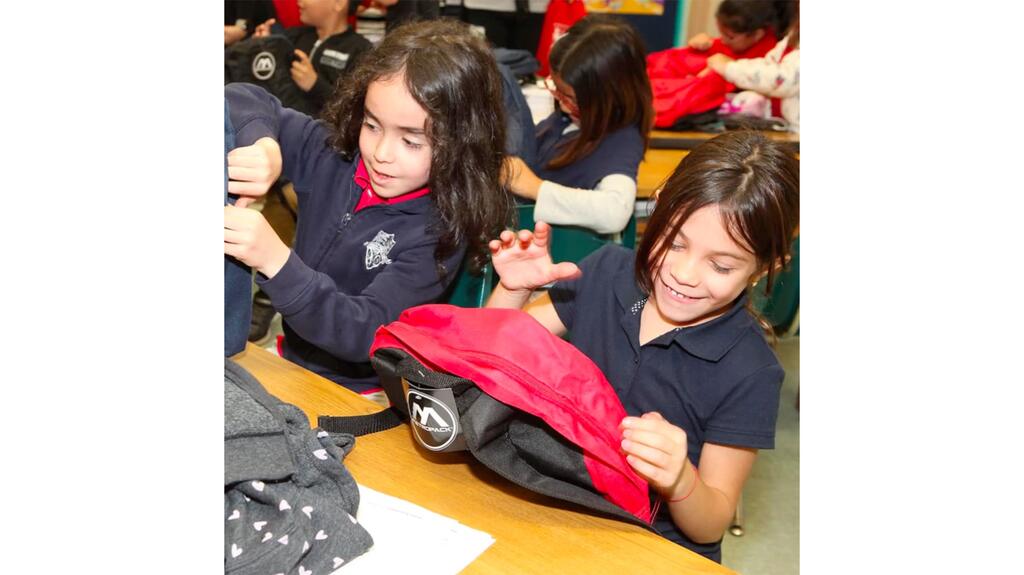 Students receiving donated backpacks