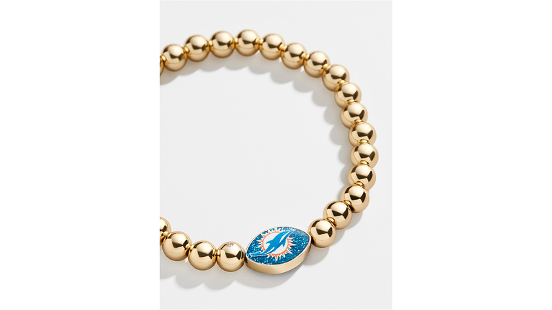 A gold-plated brass stretch bracelet featuring an enameled bead of the Miami Dolphins logo ($30)