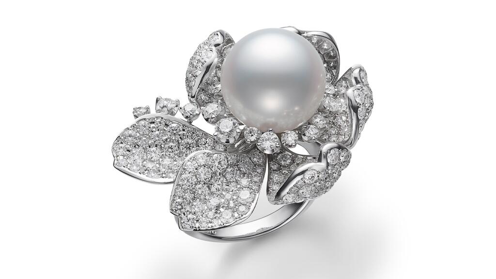 A “Les Pétales” ring featuring a cultured White South Sea pearl at the center of a diamond and 18-karat white gold rose Mikimoto Les Pétales Ring
