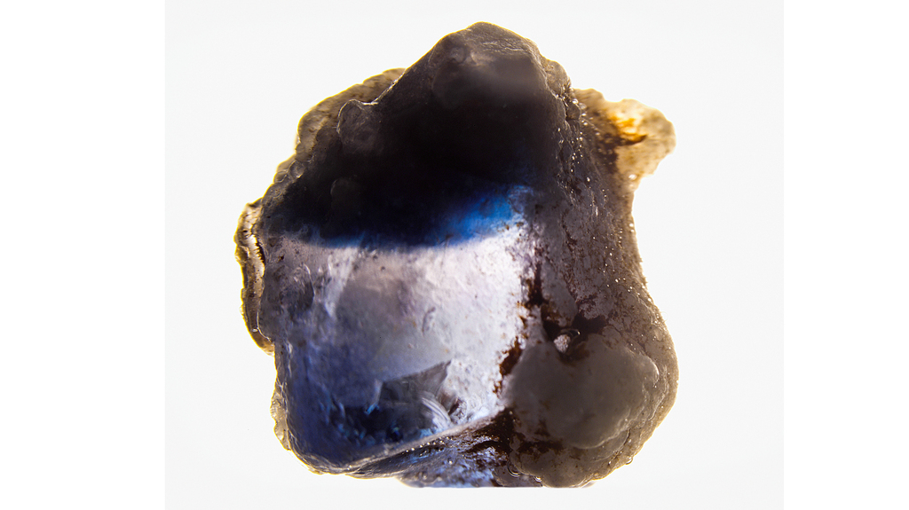 This photo shows the curved blue banding visible in the 6.21-carat laboratory-grown sapphire after being immersed in water. (Photo credit: Najmeh Anjomani) This photo shows the curved blue banding visible in the 6.21-carat laboratory-grown sapphire after being immersed in water. (Photo credit: Najmeh Anjomani)