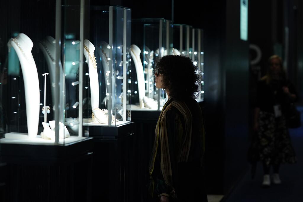 Show attendee gazes at jewelry on display