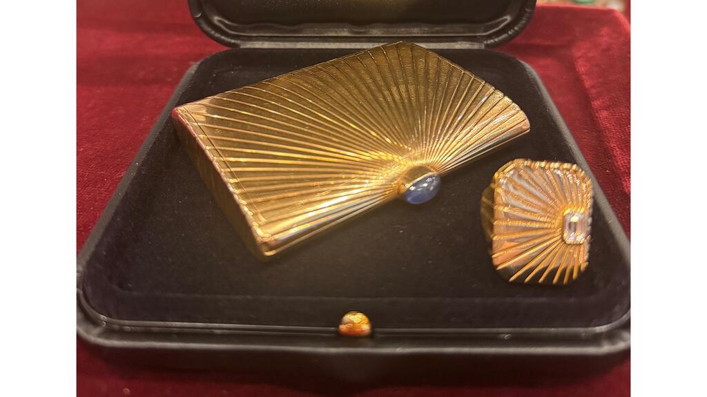 The Cartier “Sunburst Golden Compact,” circa 1960, in 18-karat yellow gold with a sapphire clasp and a ring from the “Ray of Light” collection Cartier 1960 Sunburst Golden Compact