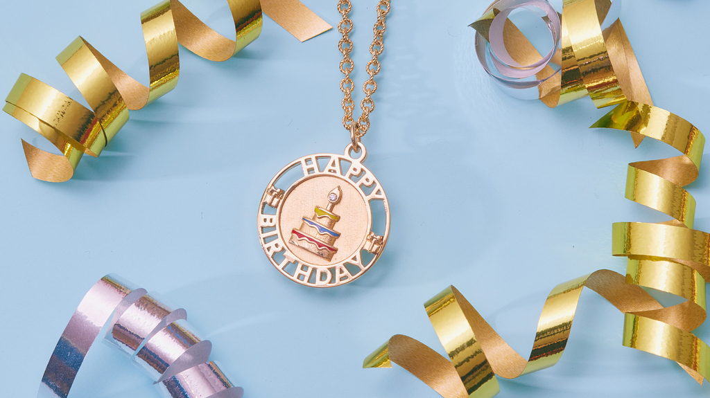 The “Happy Birthday” pendant is made in 14-karat gold and depicts a cake with blue, yellow, and red enamel, plus a diamond. Sold with an 18-inch textured cable chain it retails for $2,465.