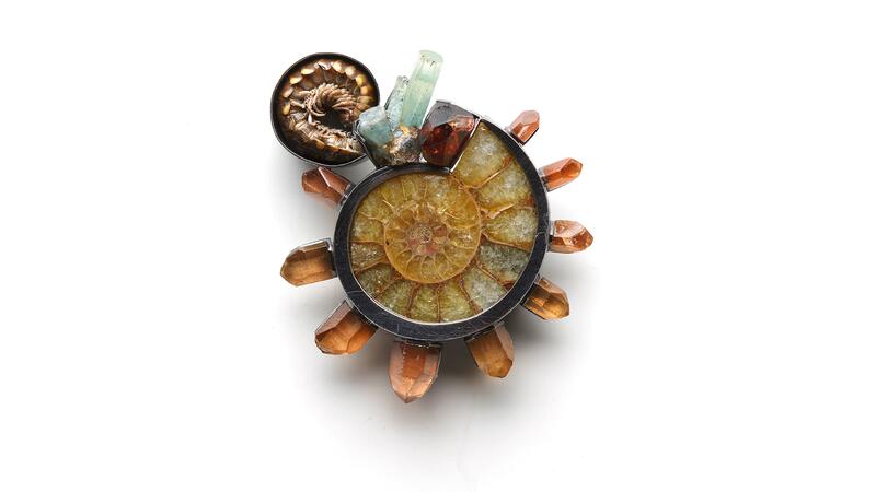 The “Radialities” brooch by Alex Lozier Jewelry in oxidized sterling silver and resin, featuring a centipede (upper left, another actual bug) and ammonite, surrounded by aquamarine, zircon, and tangerine quartz crystals. Alex Lozier Jewelry centipede brooch