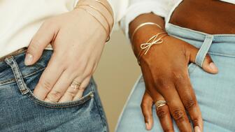 Gwen Beloti bow bangles and rings on hands